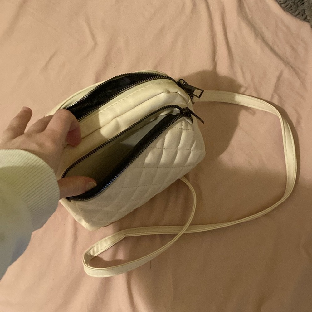 Women’s cream purse. No rips or tears, all zippers work. Has three pockets.